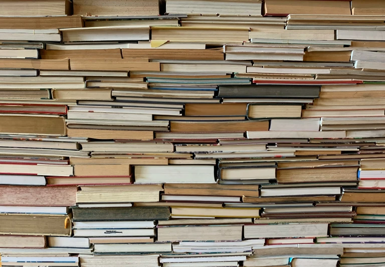 a large pile of stacked books with stacks down the middle