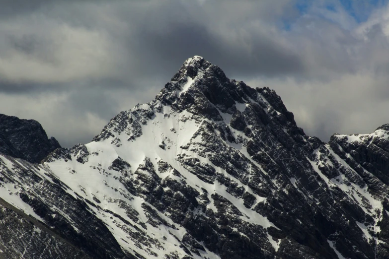 a snowy mountain peak is seen on a cloudy day