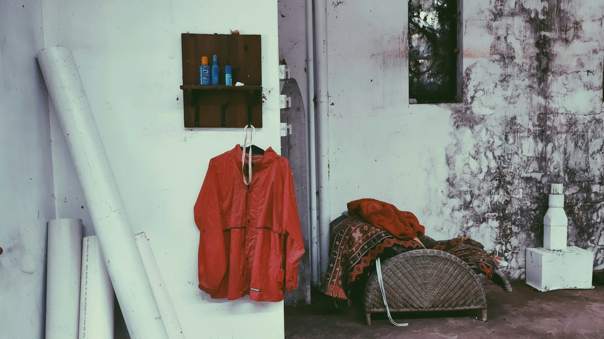 a worn and run down room with a chair, coat rack and chair