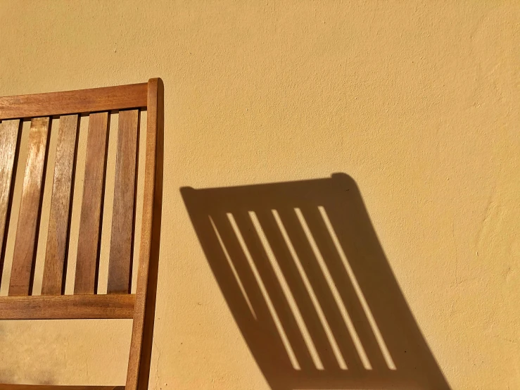 a wooden chair and a shadow on the ground