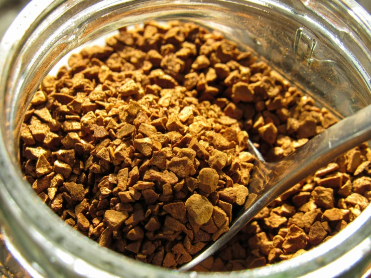 a glass jar filled with a mixture of brown dog food