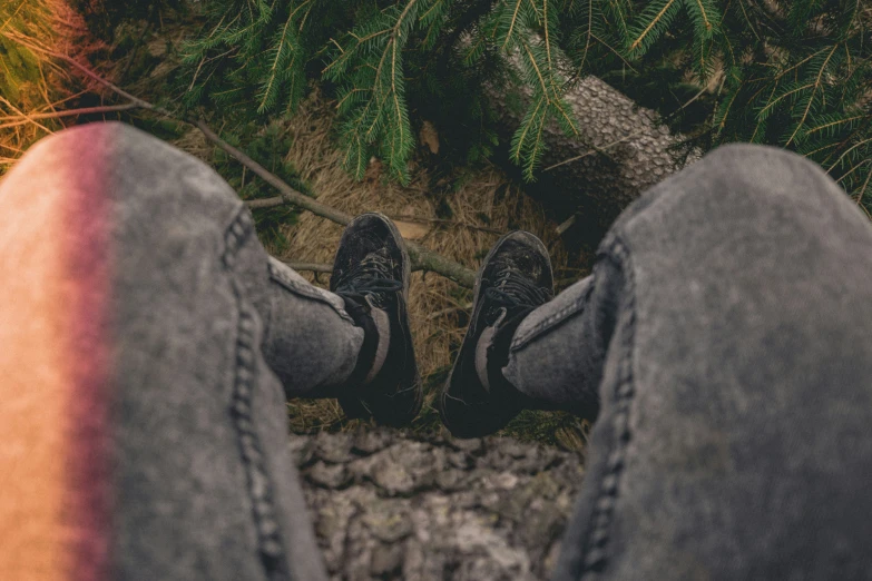 two feet on a person's foot wearing black shoes in the grass