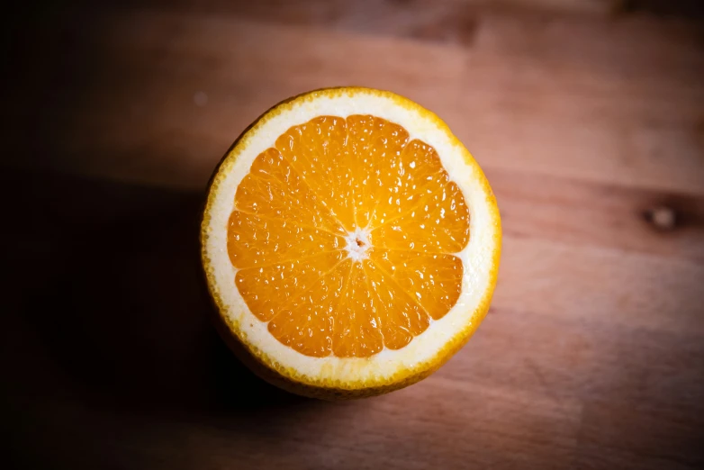 a sliced up orange sits on top of a wooden surface