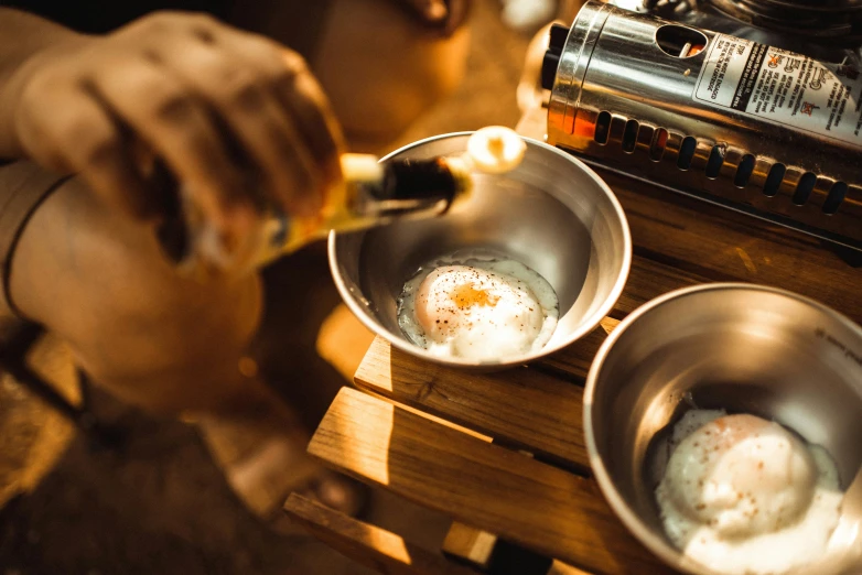 two frying pans sitting on a table top with eggs