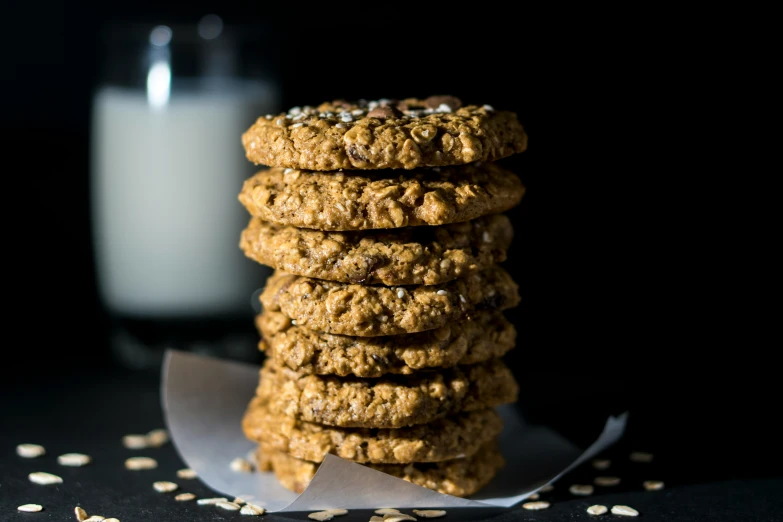 a stack of cookies next to a glass of milk