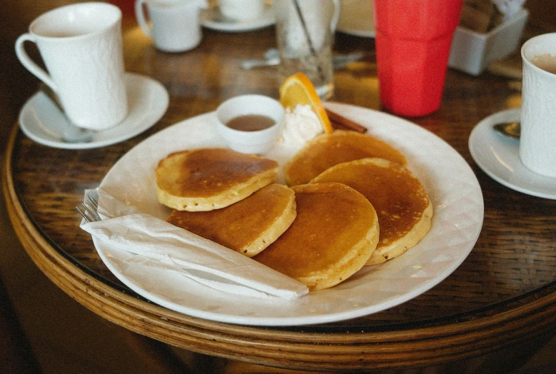 breakfast is served at the table with a cup and saucer