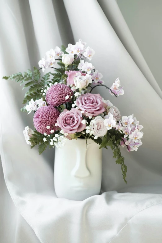 pink and white flowers in a white vase