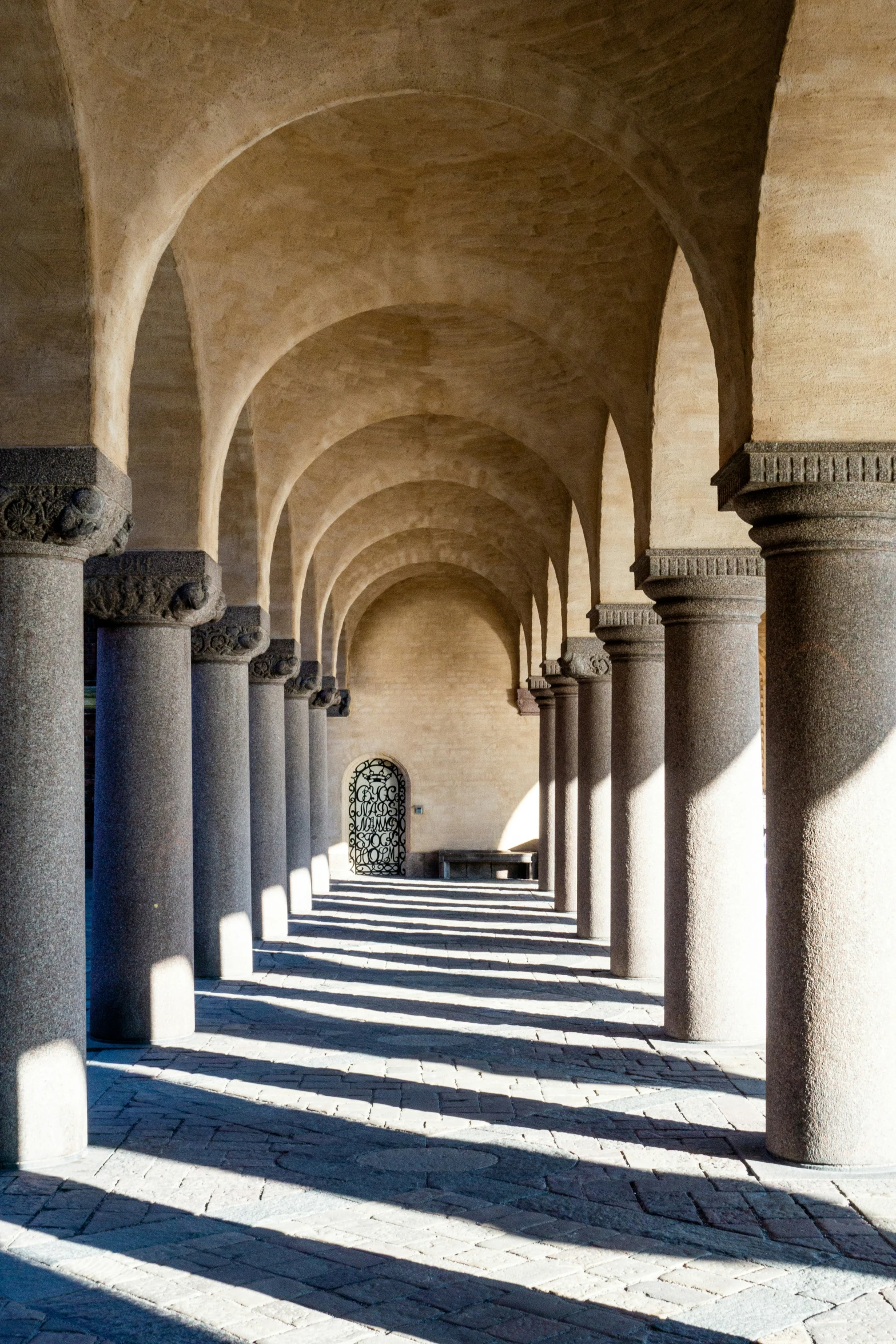 large arches and pillars line a stoned walkway