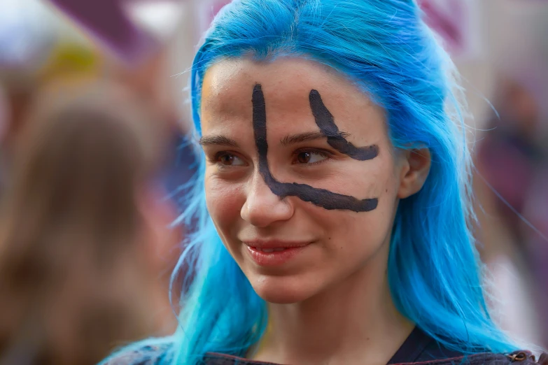 a woman with painted face art and blue hair