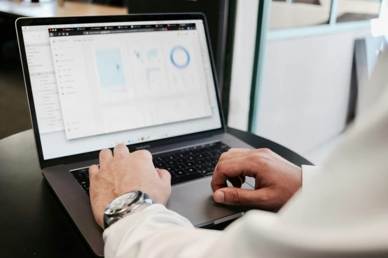 a man in a white shirt is on his laptop