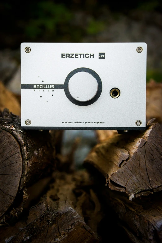 the enclosure of a electronic device sits on top of wood