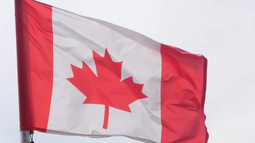 the canadian flag is flying high in the air