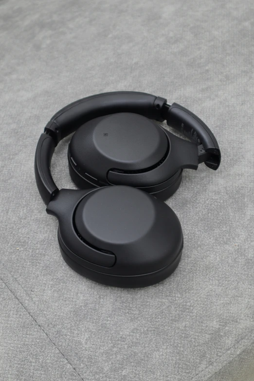 a couple of black ear buds on a gray surface