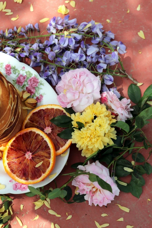 a plate of pancakes with fruit and flowers