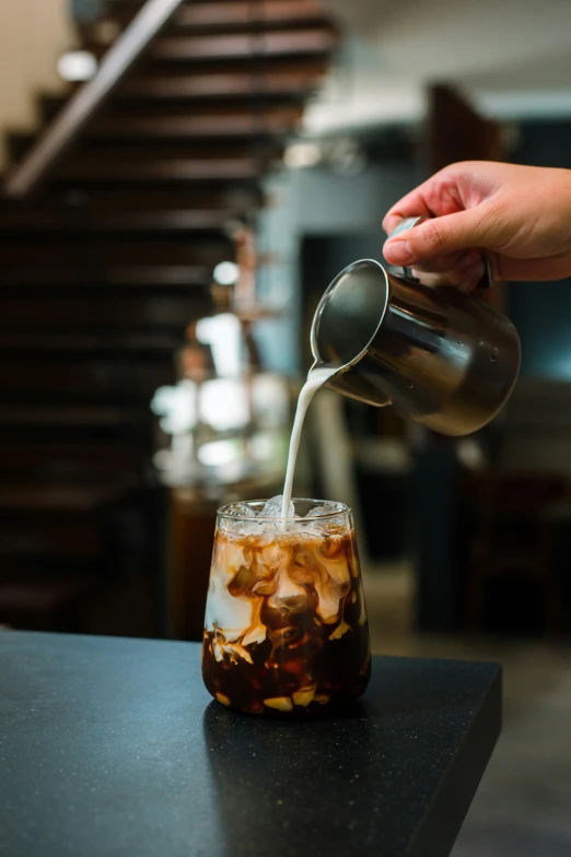 a person pours syrup into a glass