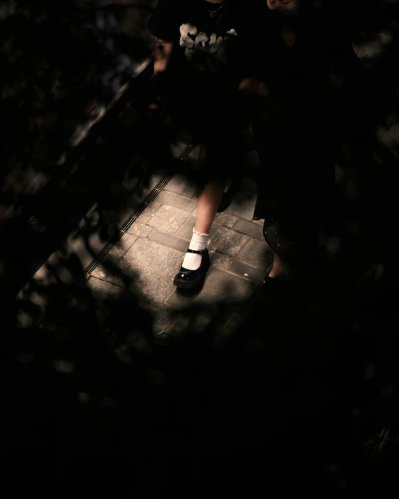 a person standing on a ledge looking down at soing in the dark