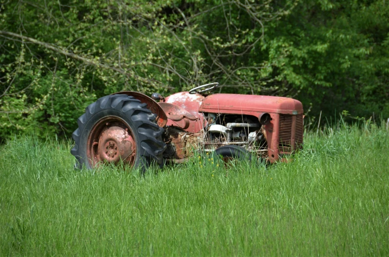 an old farmall sits on the side of the road