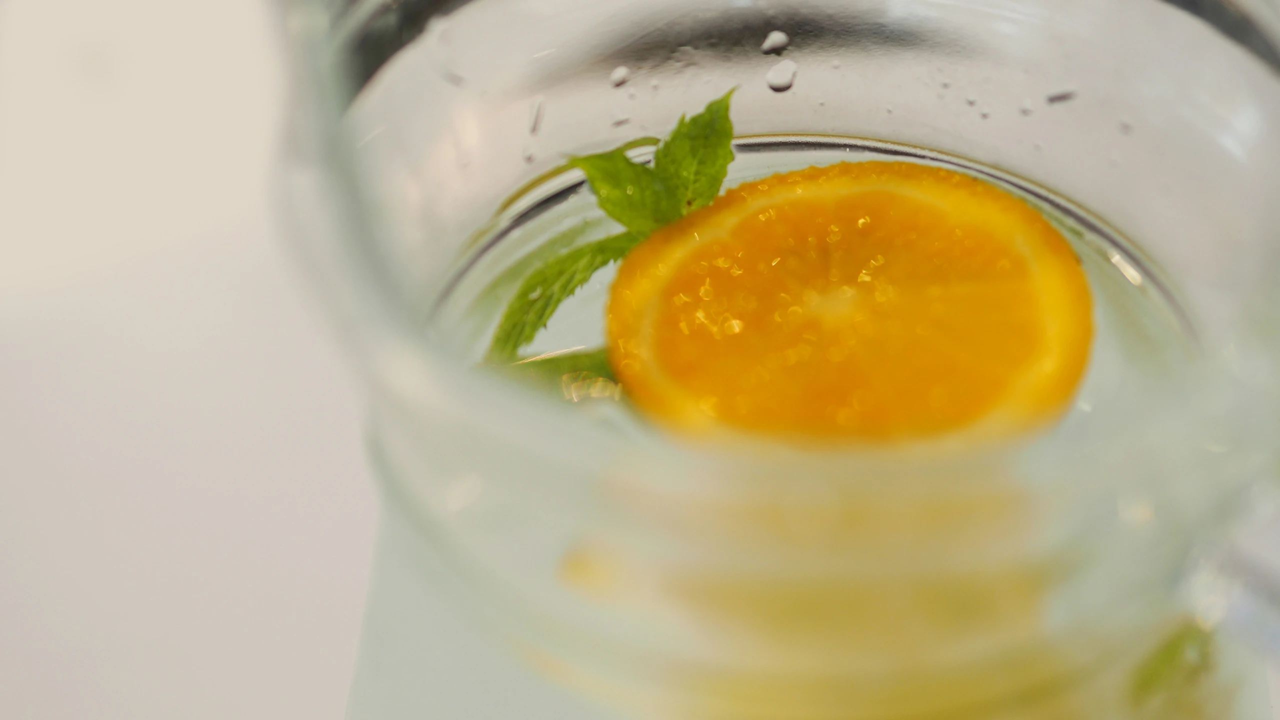 a single orange cut in half and on top of ice water