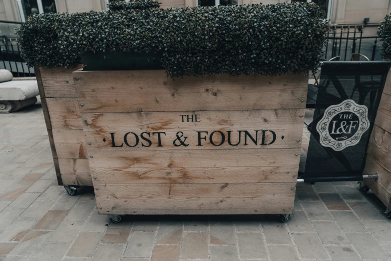 the sign is outside near the sidewalk that has the words lost and found on it