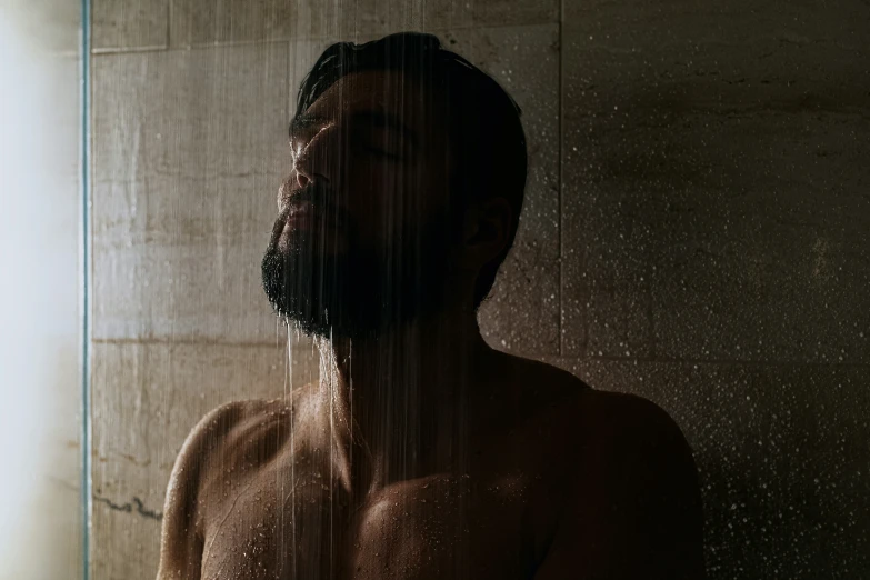 a  man in a shower with his eyes closed