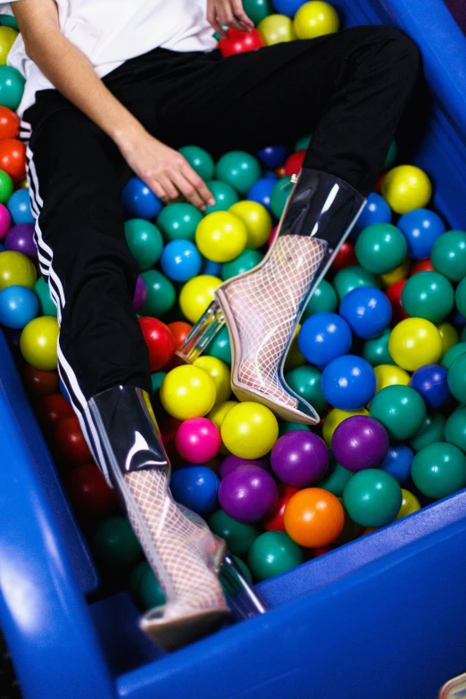 a woman sitting on top of a ball pit