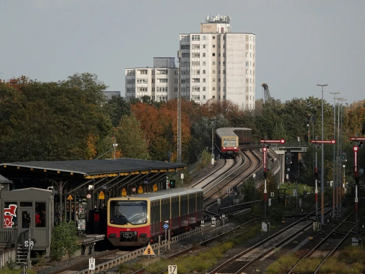 train passing through station with buildings in the background