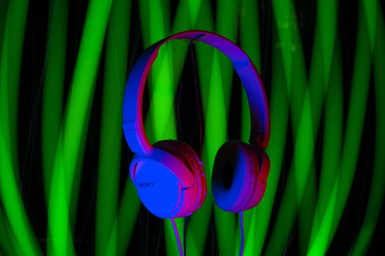 headphones in a neon green light are being used to create abstract music