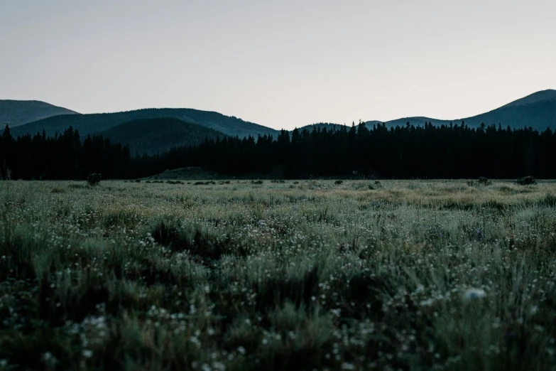 the sun rises in the horizon as there are many tall mountains on the horizon