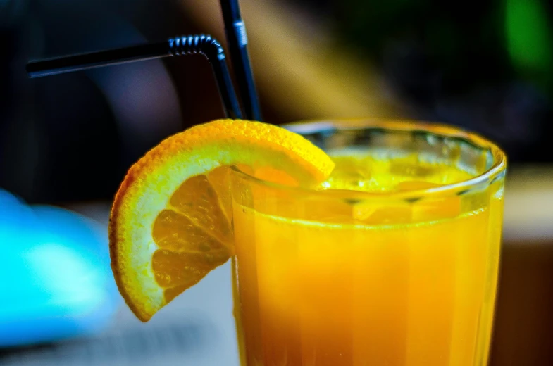 an orange sits inside of a glass with some juice
