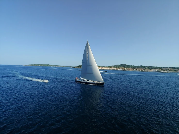 a sail boat floating in the middle of the ocean