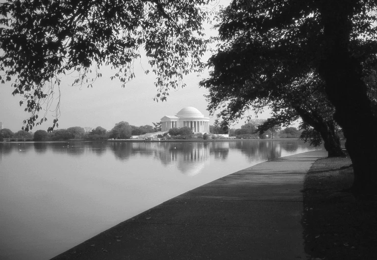 a lake with a building in it and trees on the sides