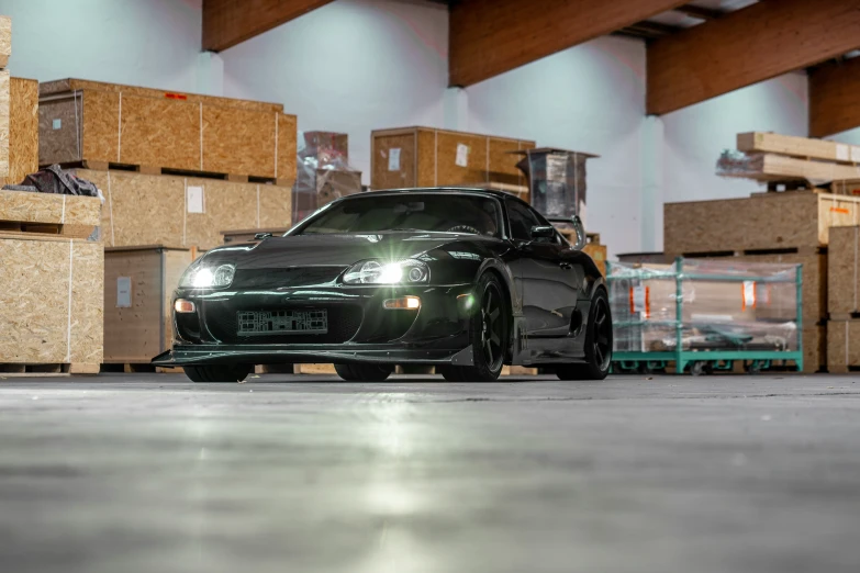 a car parked inside of a warehouse next to stacks of boxes