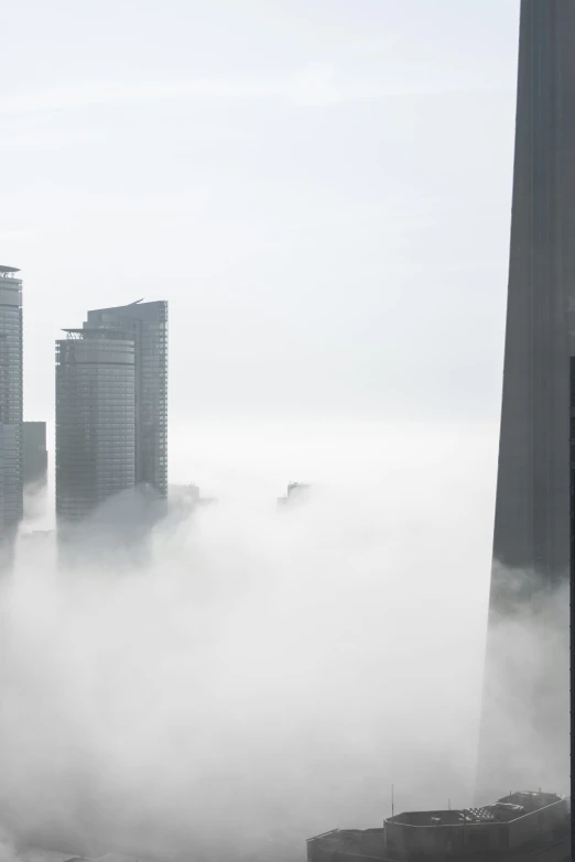 an area with buildings on the water and a big fog in the air