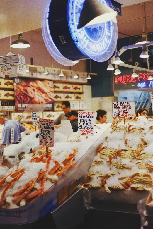 a large group of people shopping in a seafood market