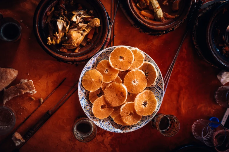 this is a bowl filled with oranges on top of a wooden table