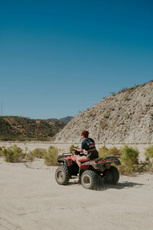 a person riding on an atv on a dirt road