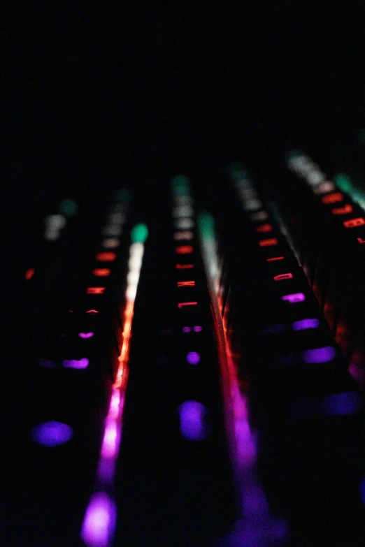 the computer keyboard is glowing brightly in the dark