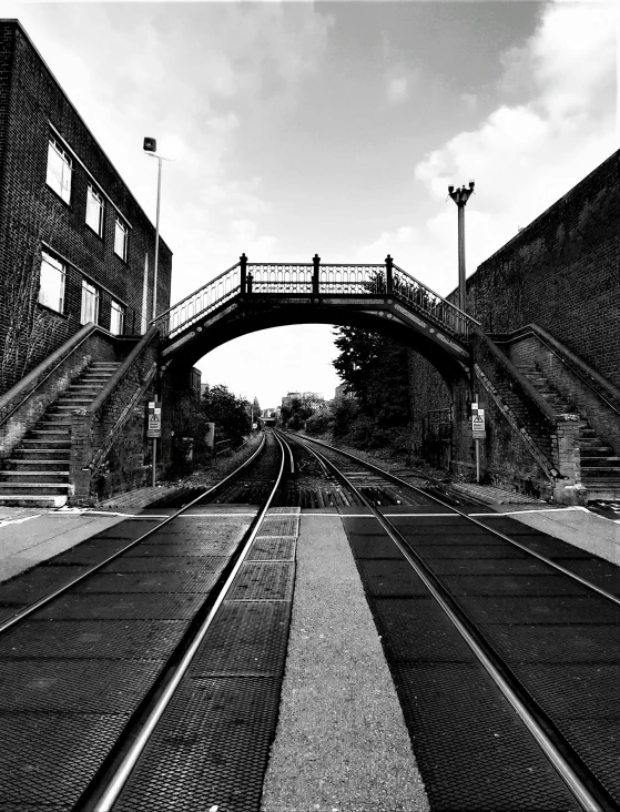 a man is walking over a bridge with rail tracks