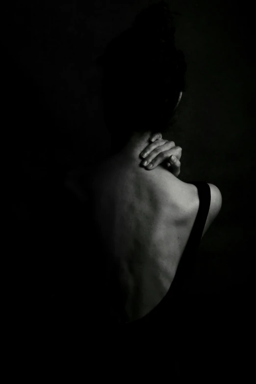 a person in a dark room with their back to the camera