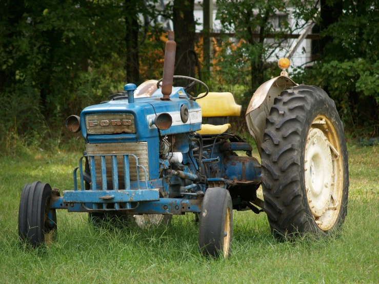 a blue tractor parked on top of a lush green field