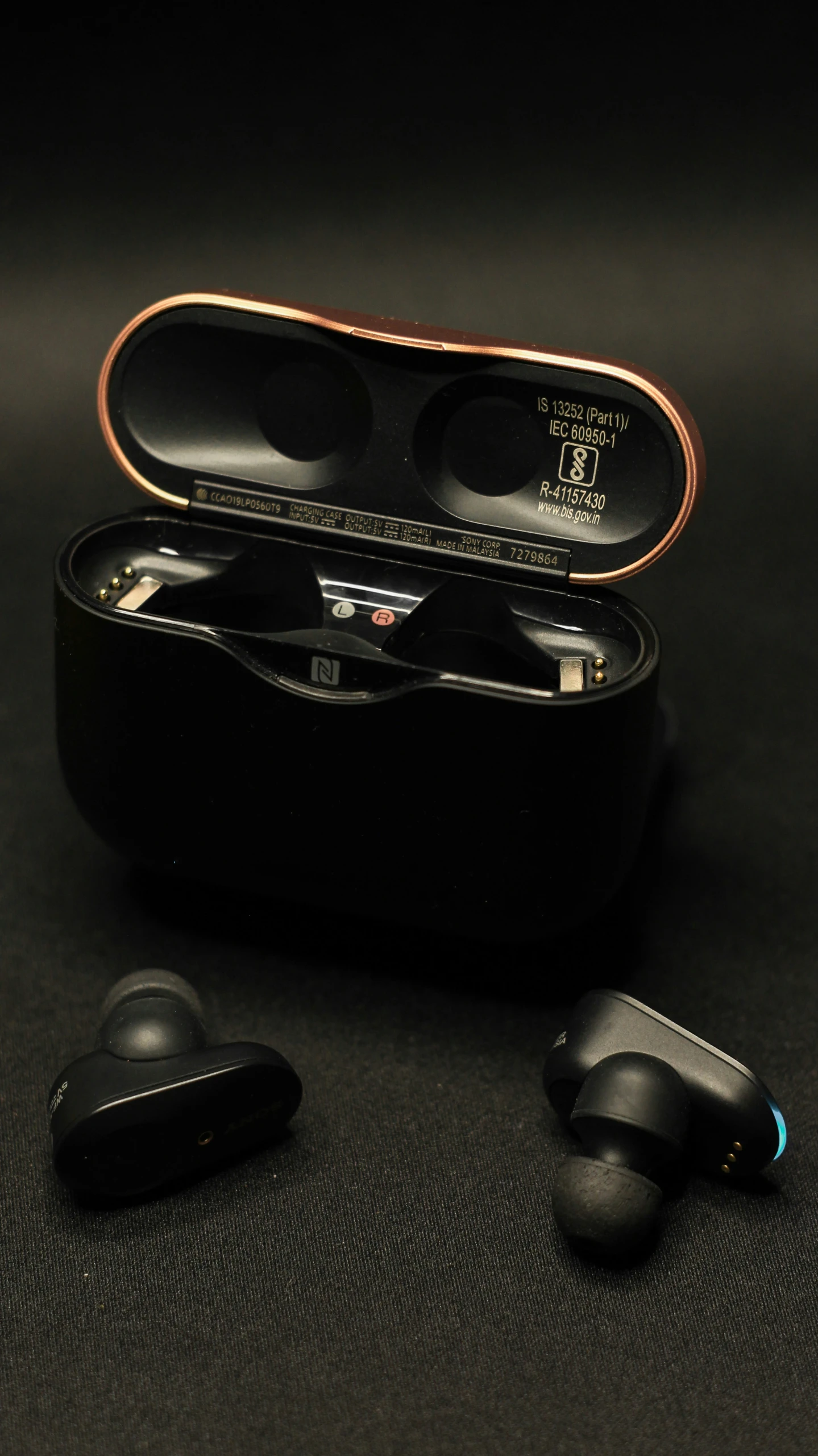 a case with two different earbuds sitting inside of it