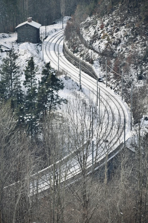 an aerial view of a snowy road and small farm