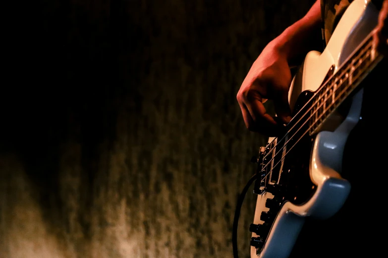 a person with a guitar near a wall