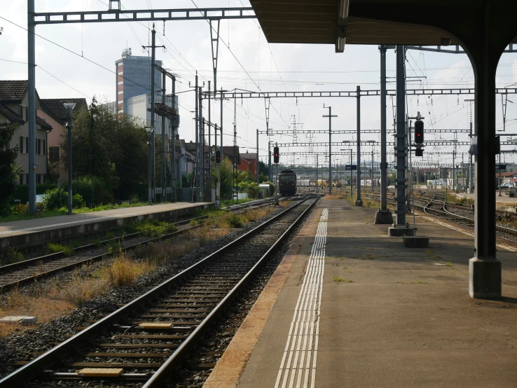 the platform at an empty train station with lots of wires above