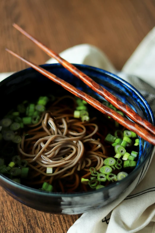 noodles with green onions are being displayed in a bowl