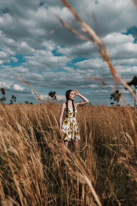 a woman wearing a floral dress in a field