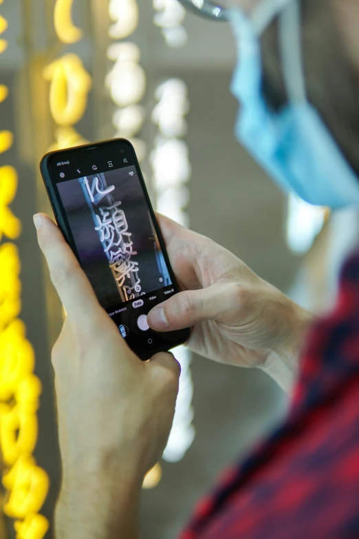 a person with a medical mask uses their cell phone