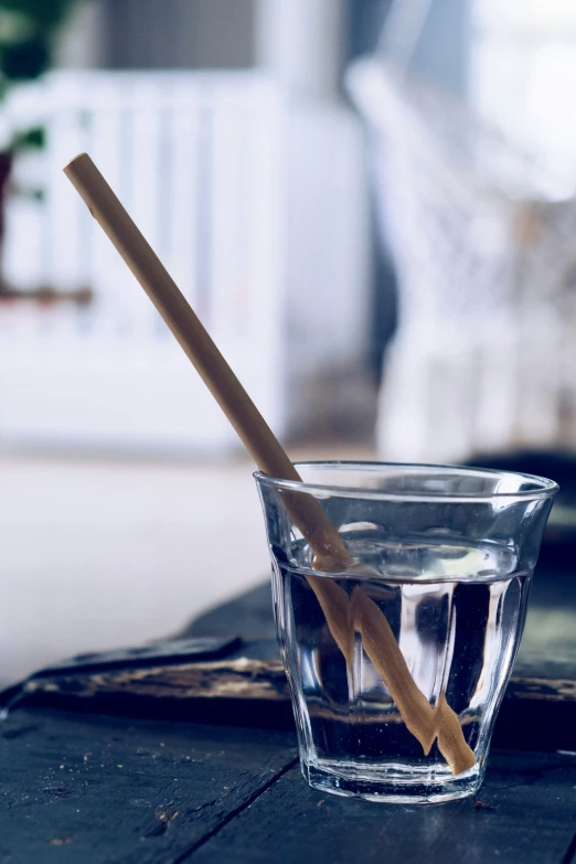 the glass is full of water with a stick sticking out of it