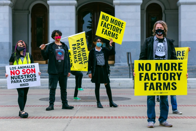 a group of people standing around each other with yellow signs