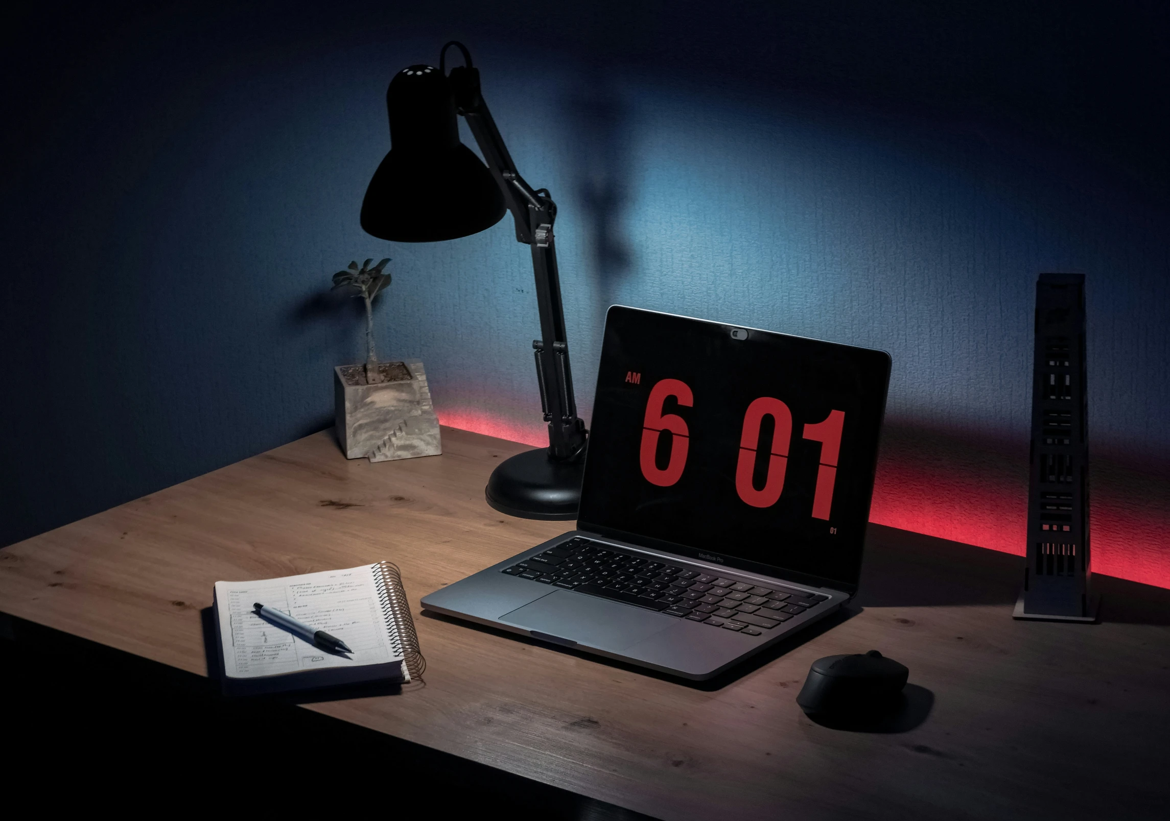 an illuminated lamp on a desk next to a laptop